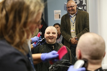 student having hair shaved for cancer