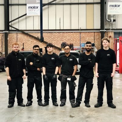 Mechanics lined up in workshop