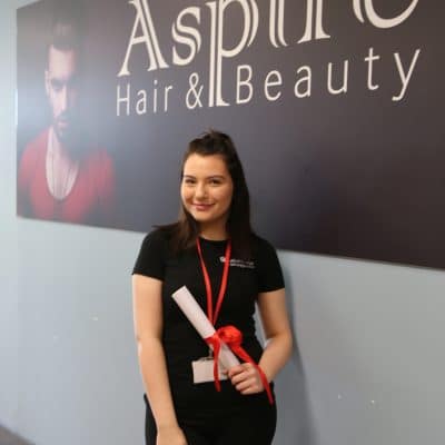 Hair & beauty student stood infront of aspire sign