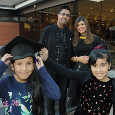 Family celebrating at graduation with two children in foreground