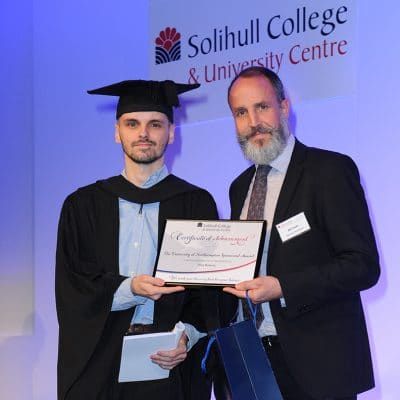 Student at graduation holding certificate