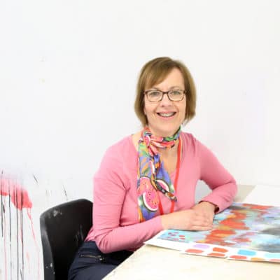 Art student sat with work at a desk