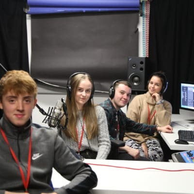 four students sat in a recording studio