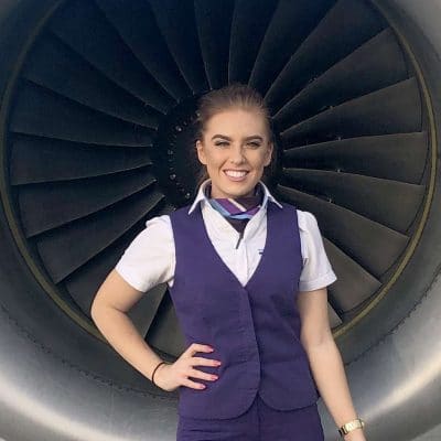 Student stands in front of a jet engine