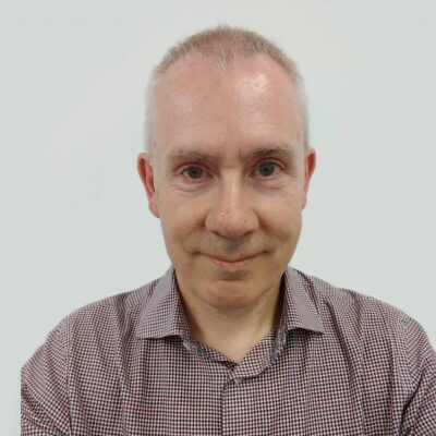 Paul Hanna stood in front of a grey wall.