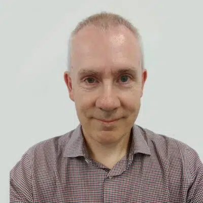 Paul Hanna stood in front of a grey wall.