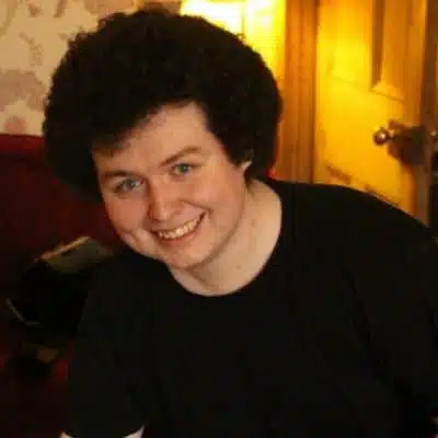 Adam Gwenter smiling for the camera in a black tshirt