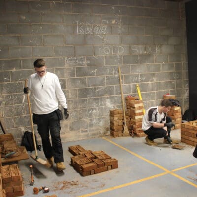 student dusts his area with a broom