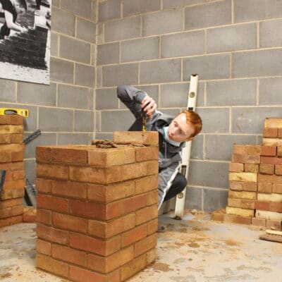 a red headed student creates brick wall