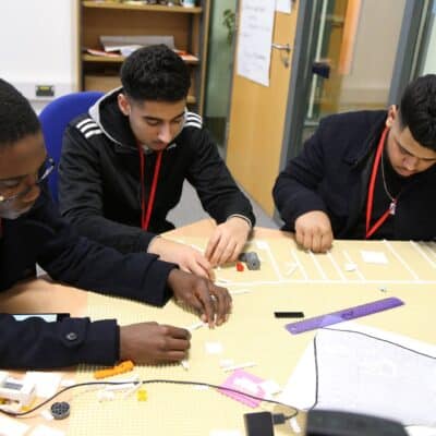 3 male students working at a desk