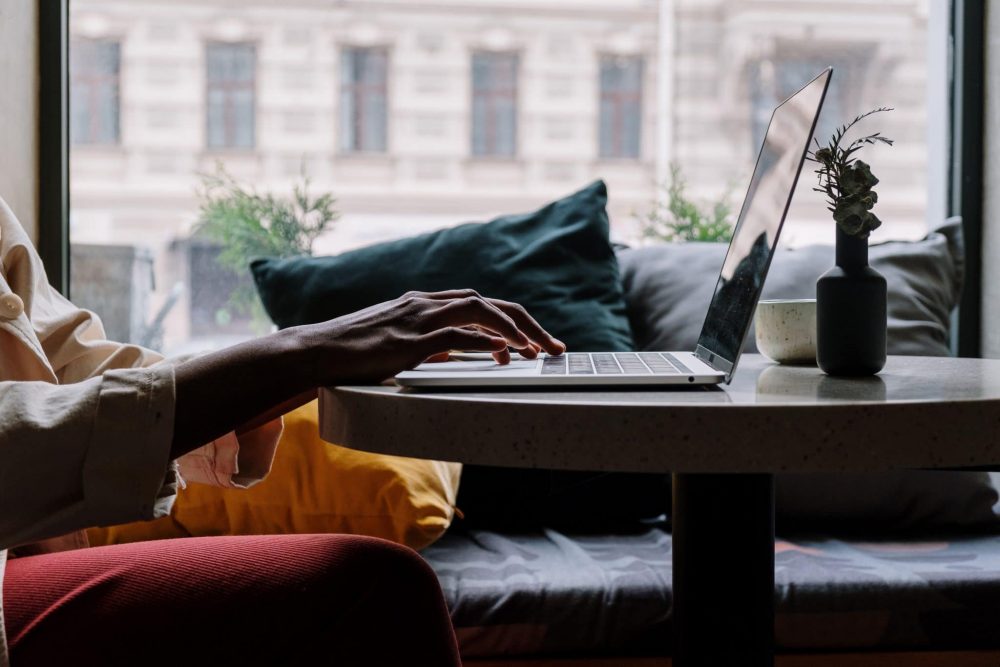 a laptop on a table with hands typing