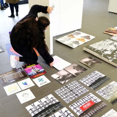 a student picks up posters off the floor