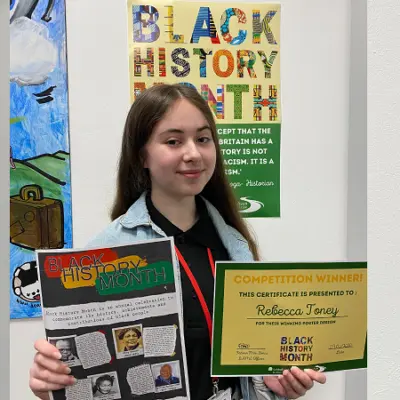 Beca holding up her poster and certificate.