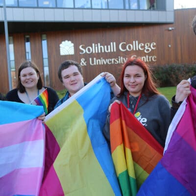 Students from the college including Will Pullen in the centre hold a flags for LGBT+ history month.
