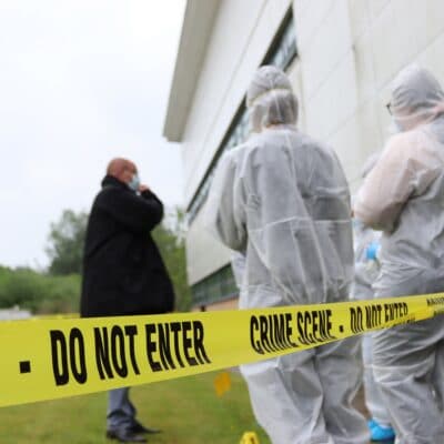 crime scene tape and students in the background