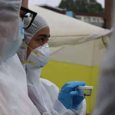 a female student in a boiler suit holds evidence