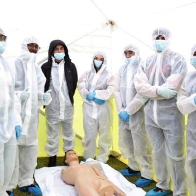 Students stood in boiler suits in the crime scene tent