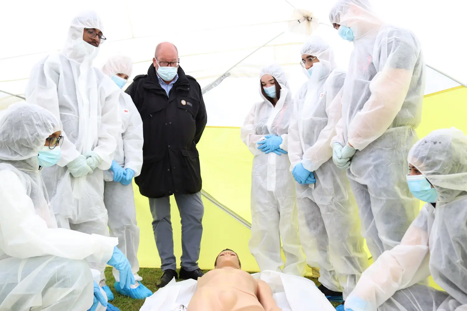 Students stood in boiler suits in the crime scene tent with Andy