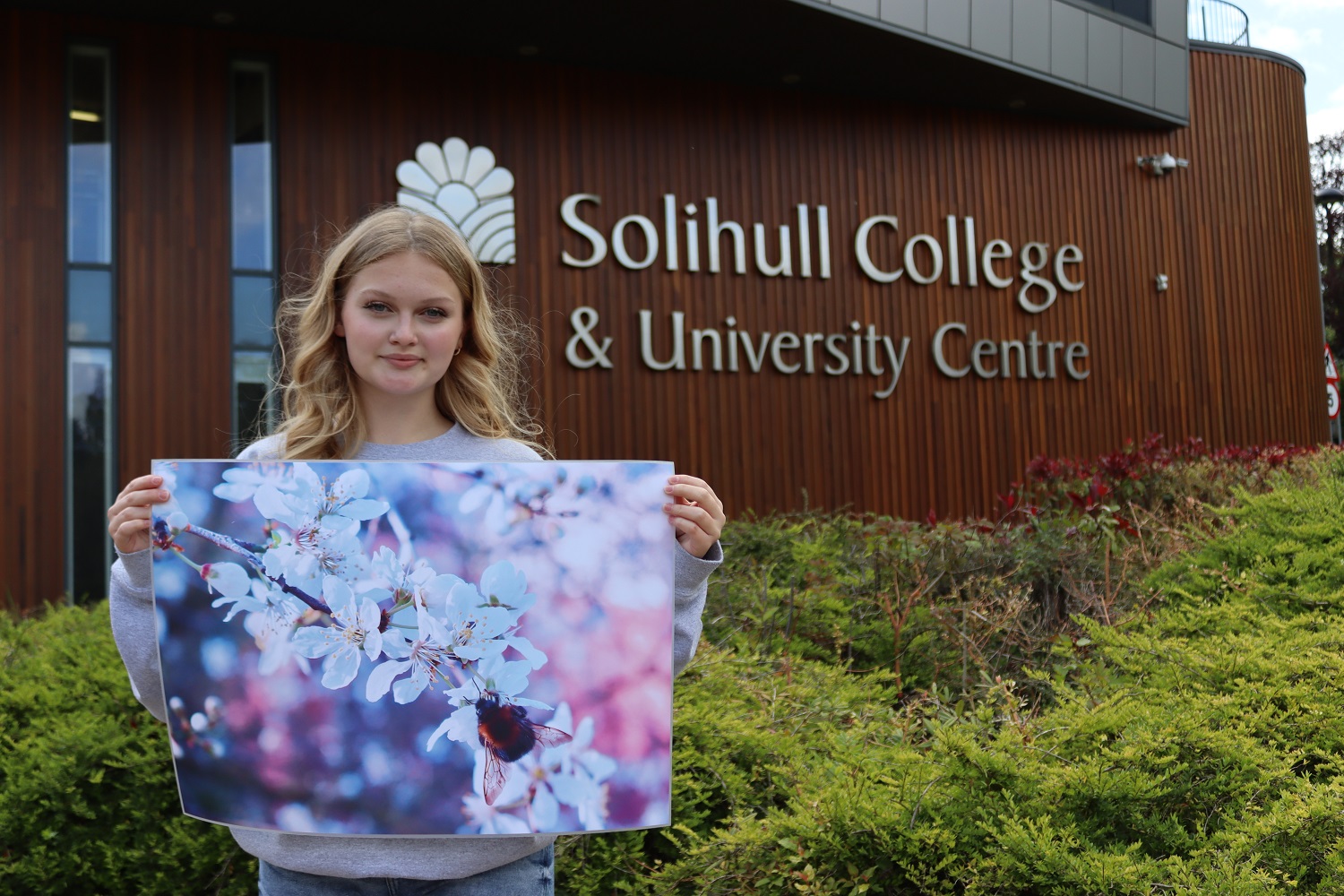 Hattie with a previous competition entry winning shot from another occasion stood outside the college