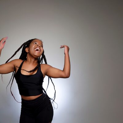student flicking her hair with arms in air