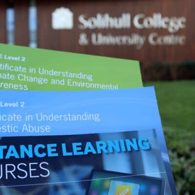 Course books in front of college building