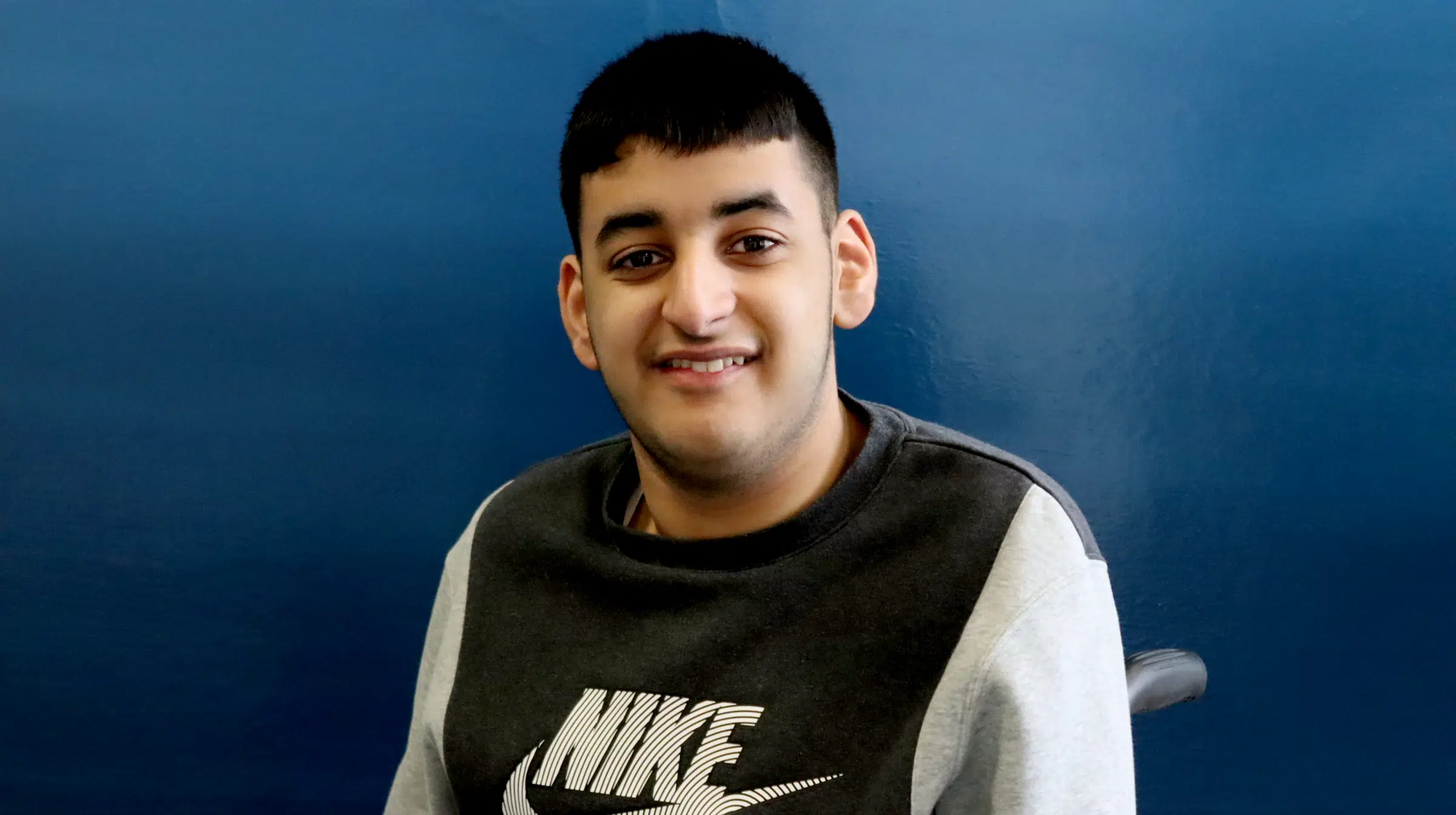 Student looking at camera with blue background