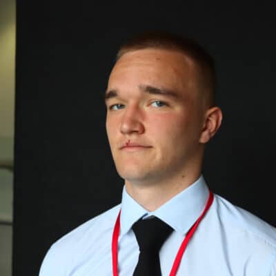 student looking at camera with black background