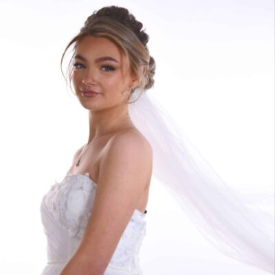 Bride standing to one side wearing white dress