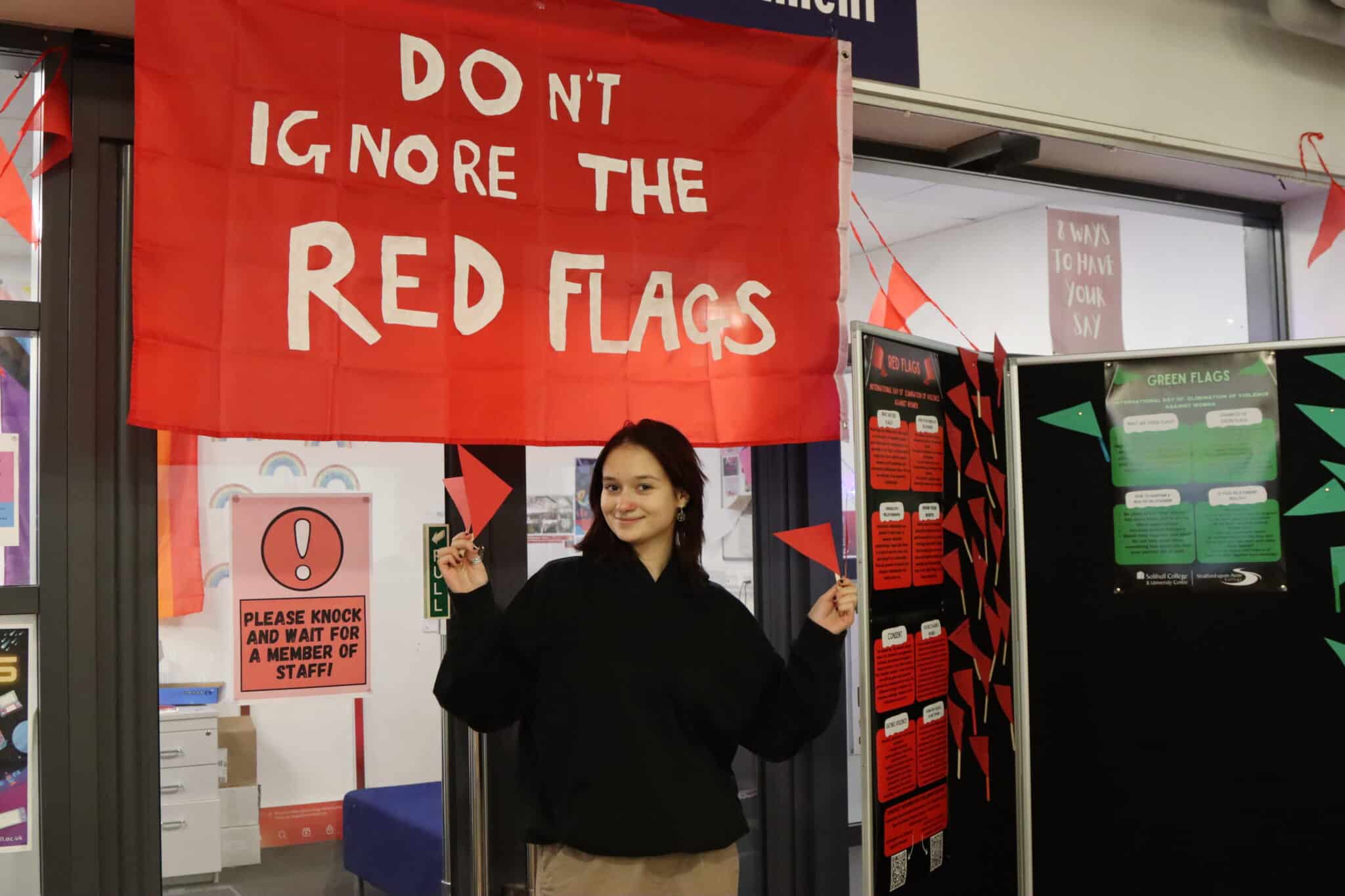 Don't ignore the red flags banner in background student holding flags in front