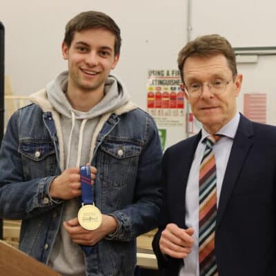 Harry standing next to Mayor Andy Street holding medal