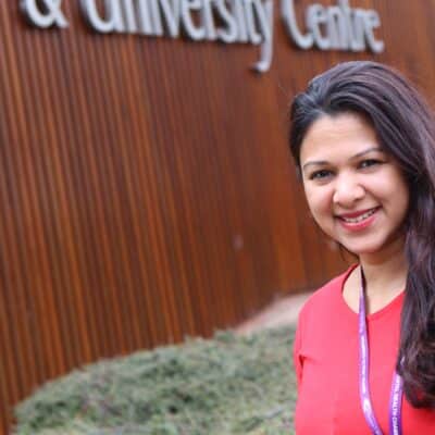 Fathima in front of College in red top