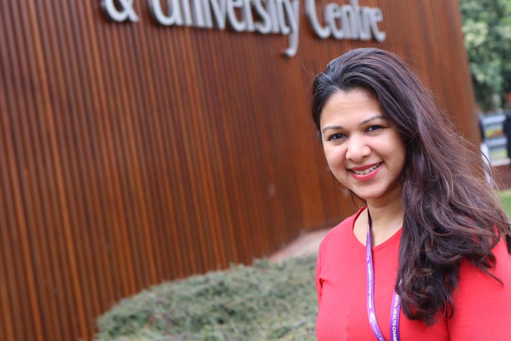 Fathima in front of College in red top