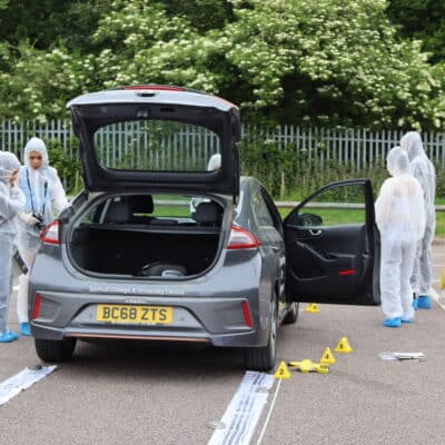 Forensic students investigating a traffic accident simulation.