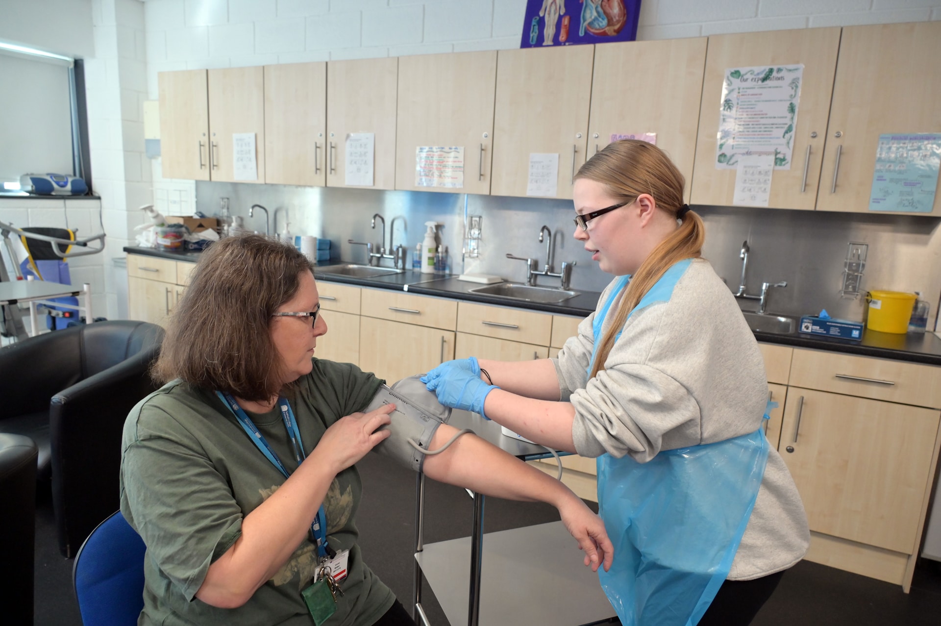 Student measures person's blood pressure in classroom setting.
