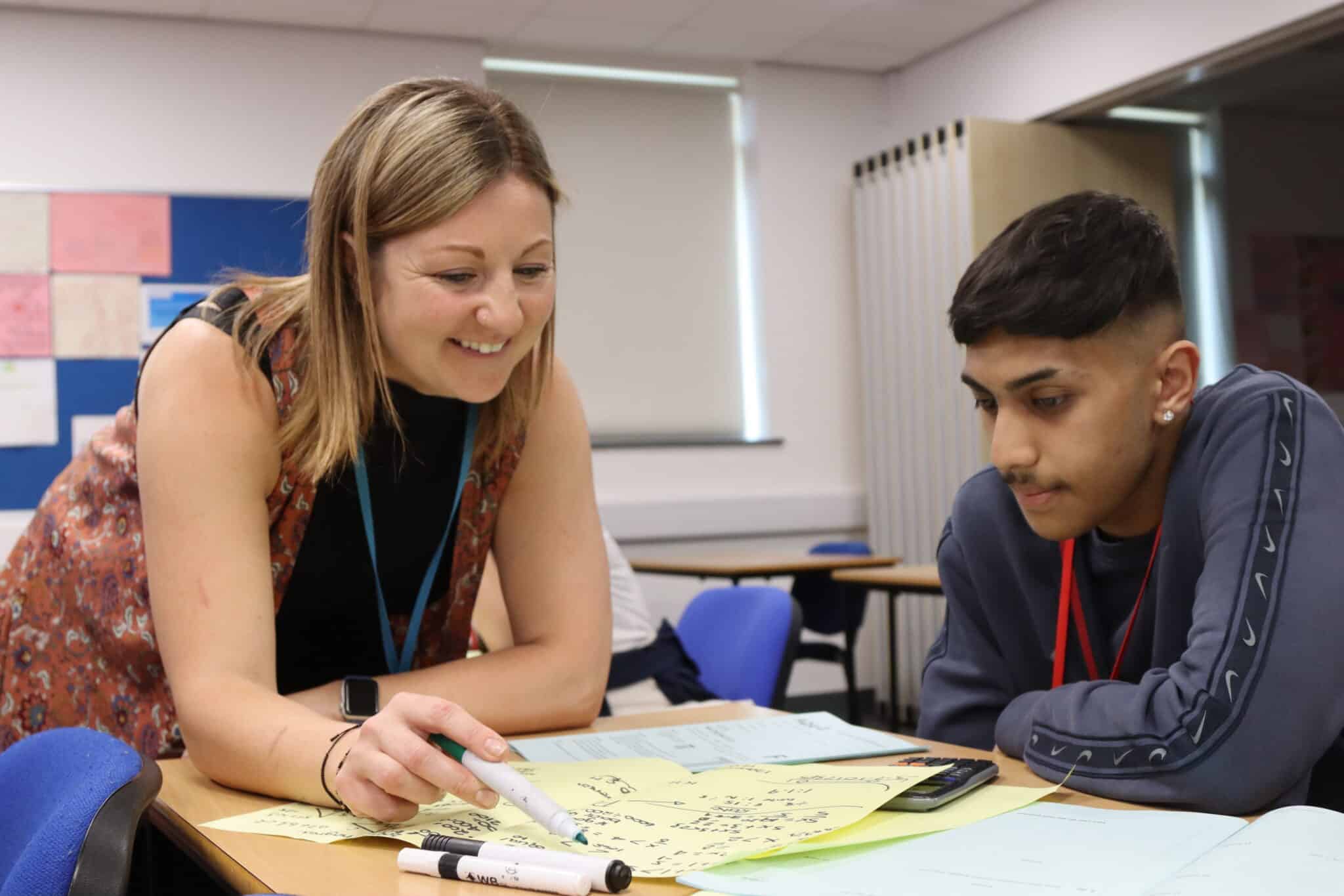 Maths teacher Holly working with a student in the classroom