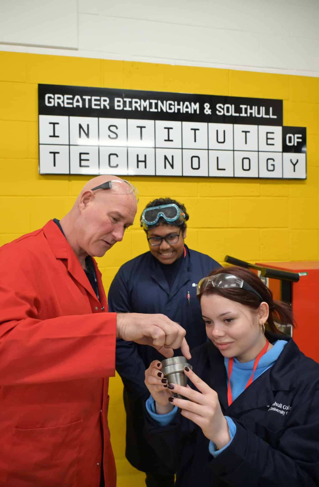 Engineering students and lecturer in front of sign: 'Greater Birmingham & Solihull Institute of Technology'