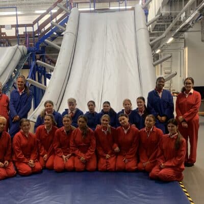 cabin crew students standing in front of a huge slide