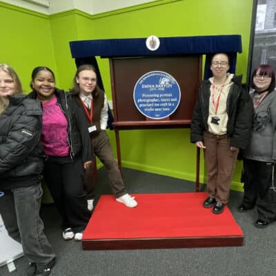 Photography students commemorate industry pioneer - 5 students stood next to blue plaque Emma Barton
