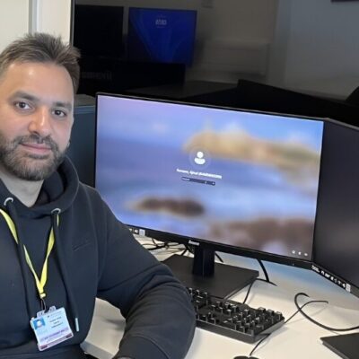 student sat in front of computer looking at camera