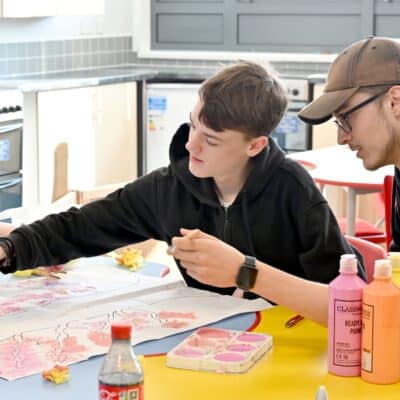 students working at a desk with colourful pictures working in childcare