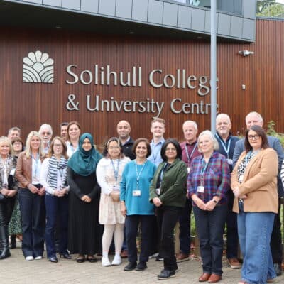 Group of Solihull College staff standing in front of college
