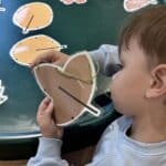 child playing with pictures of leaves