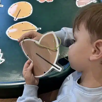 child playing with pictures of leaves