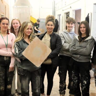 female plasterer standing with female plastering students