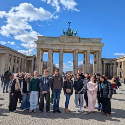 Students smiling in front of a tower