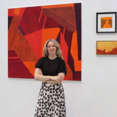 Ruth Millington standing in front of some of the featured artwork