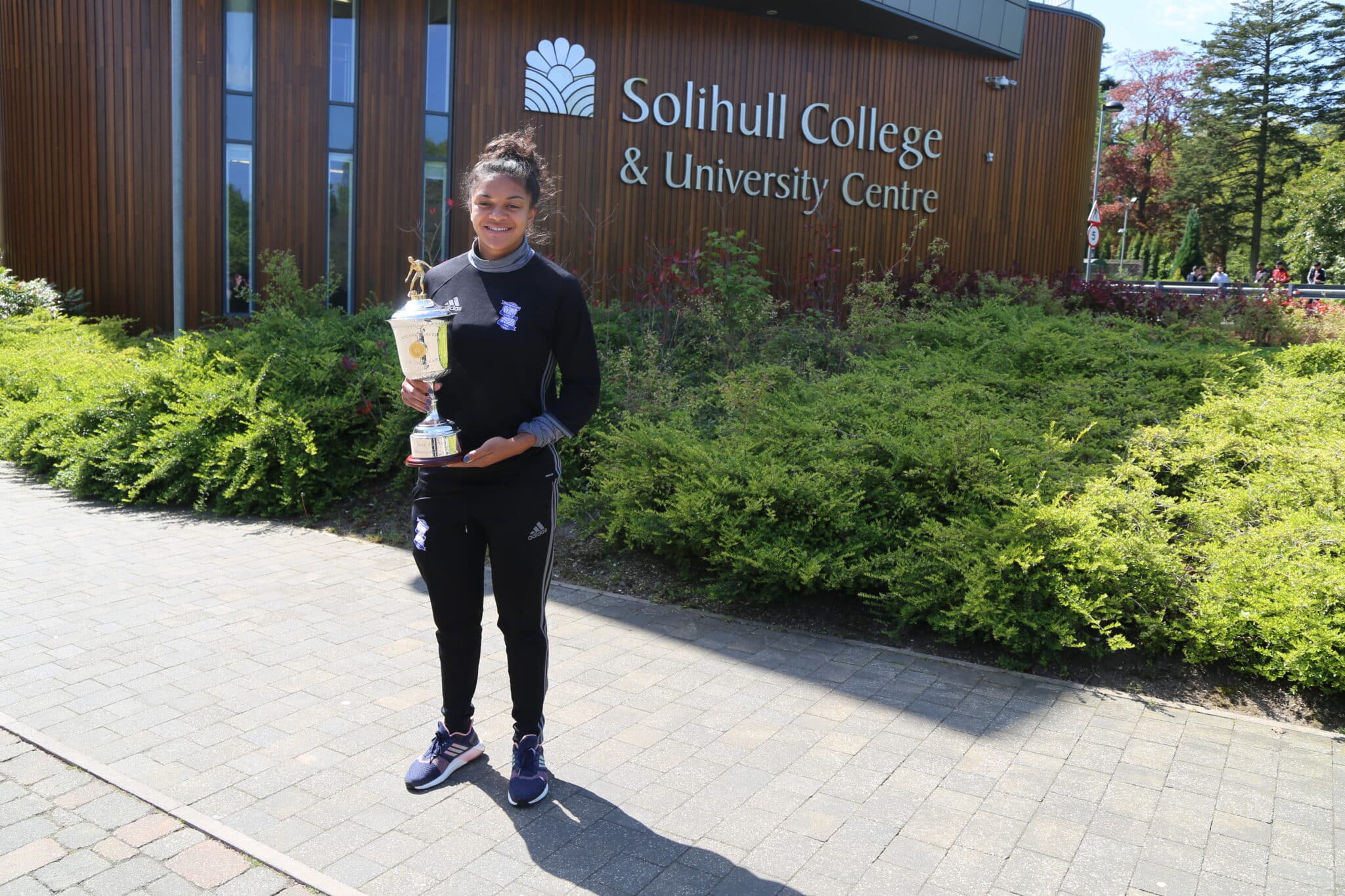 Jess with her PFA Young player of The Year award in 2017 outside the college