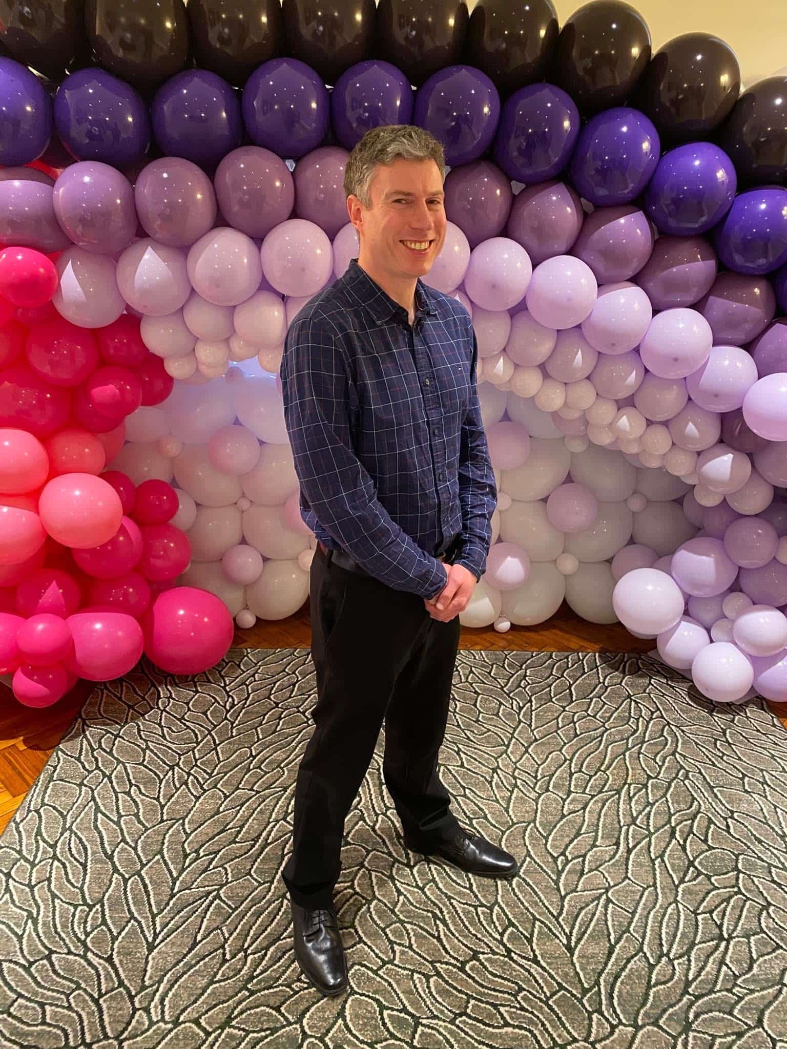 Richard Newell standing in front of balloons