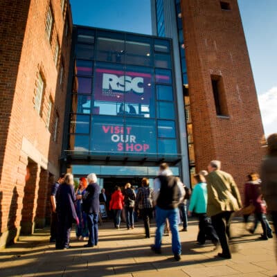 Front of Royal Shakespeare Company Theatre with patrons walking through the main entrance.