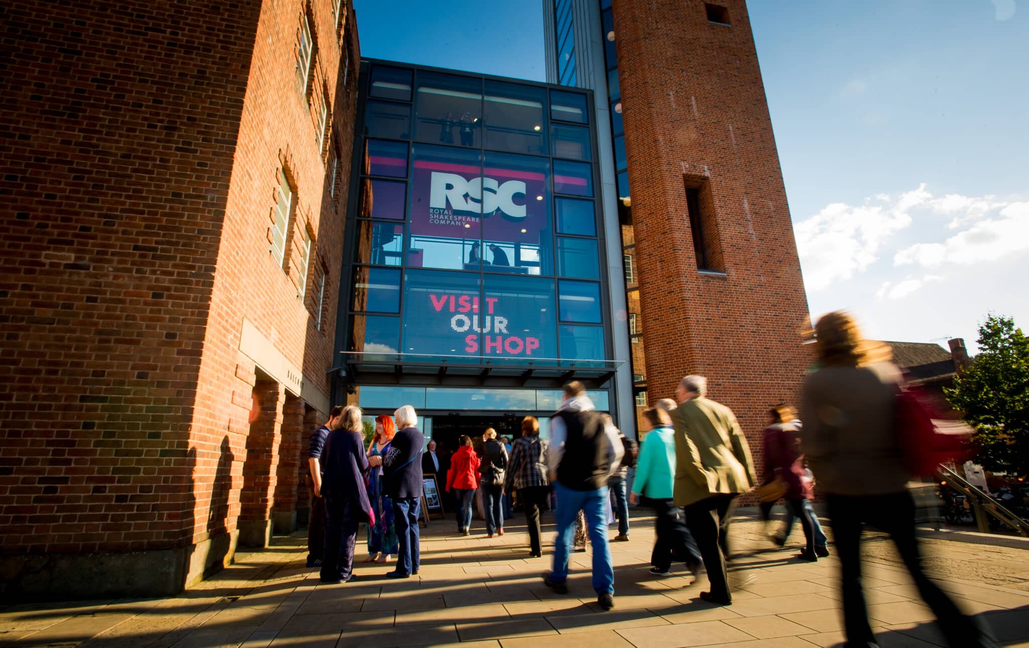 Front of Royal Shakespeare Company Theatre with patrons walking through the main entrance.